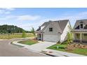 View of a two-car garage, green lawn, and manicured shrubbery on a sunny day at 1659 Tielman Way, Snellville, GA 30078