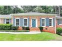 Charming brick home featuring a lush front lawn, and eye-catching blue shutters and door at 1744 Chateau Dr, Dunwoody, GA 30338