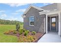 Inviting front entrance with gray brick, shuttered windows, and professional landscaping at 248 Nesta Grove, Locust Grove, GA 30248
