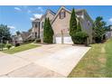 View of brick home showing driveway, two-car garage and trimmed trees next to the garage at 3717 Shady Maple Dr, Stonecrest, GA 30038