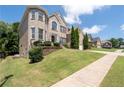 Brick home showing manicured lawn, a walkway and other homes in the background at 3717 Shady Maple Dr, Stonecrest, GA 30038
