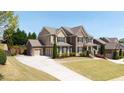 Beautiful two-story home with a brick facade, three-car garage, and a long driveway on a sunny day at 622 Rocky Creek Pt, Woodstock, GA 30188