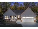 Twilight view of a charming home with white siding, stone accents, and a welcoming front porch at 728 Harmony Rd, Temple, GA 30179