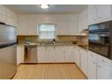 Bright kitchen with stainless steel appliances, granite countertops, and white cabinets at 2808 Peeler Rd, Dunwoody, GA 30360