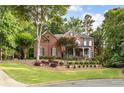Charming two-story brick home with a welcoming front porch and meticulously maintained landscaping at 3750 Maryhill Nw Ln, Kennesaw, GA 30152