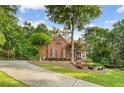 Beautiful brick home on a landscaped lot with a long driveway and mature trees in the background at 3750 Maryhill Nw Ln, Kennesaw, GA 30152
