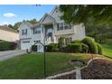 Well-maintained home with lush landscaping, a two-car garage, and stone accents at 107 Hearthstone Walk, Woodstock, GA 30189
