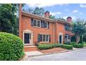 Brick townhome showcasing a symmetrical design with dark shutters and meticulously maintained landscaping at 3074 Vinings Ridge Se Dr, Atlanta, GA 30339
