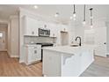 Well-appointed kitchen showcasing white cabinetry, stainless steel appliances, and a functional island with a sink, ideal for cooking at 174 Bluffington Way, Marietta, GA 30066