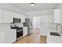 Well-lit kitchen with stainless steel appliances, white cabinets, and a white subway tile backsplash at 1955 Pius Dr, Ellenwood, GA 30294