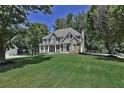 Well-maintained two story home with a sprawling lawn and tree-lined perimeter on a sunny day at 6425 Riley Manor Way, Cumming, GA 30028