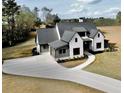Lovely two-story home with a white brick and siding exterior, a gray roof, and a spacious driveway at 115 Palisade Dr, Rydal, GA 30171