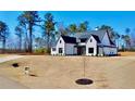 Beautifully designed house with white brick, black roof, and a large lot, set back from the street at 115 Palisade Dr, Rydal, GA 30171