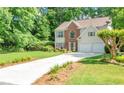Charming two-story home with a brick facade, complemented by a well-manicured lawn and lush greenery at 190 Crestworth Ct, Powder Springs, GA 30127