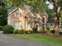 Attractive brick home featuring a well-kept lawn, mature trees, and a winding driveway at 365 Falling Creek Bnd, Duluth, GA 30097