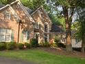 Beautiful brick home with arched window and lush green landscape at 365 Falling Creek Bnd, Duluth, GA 30097