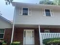 Close view of a two-story townhouse with neutral siding and brick facade at 5950 Wintergreen Rd, Norcross, GA 30093