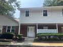View of a two-story townhouse with light siding, white trim, and brick facade at 5950 Wintergreen Rd, Norcross, GA 30093
