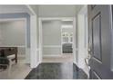 Inviting foyer with marble tile flooring, white trim, and views into multiple living spaces at 718 First Cotton Dr, Powder Springs, GA 30127