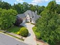 Aerial view of the home showing the long driveway, mature trees, and landscaping around the property at 9745 Autry Falls Dr, Alpharetta, GA 30022