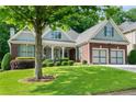 A beautifully landscaped front yard enhances this brick home's curb appeal at 1290 Magnolia Park Cir, Cumming, GA 30040