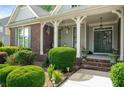 Inviting front porch with columns and lush landscaping, perfect for relaxing at 1290 Magnolia Park Cir, Cumming, GA 30040