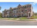 A row of townhouses showcasing brick and stone exteriors with inviting entrances and manicured lawns at 1956 Deco Dr, Kennesaw, GA 30144