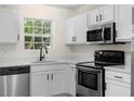 Well-lit kitchen featuring stainless steel appliances, white cabinets, and modern countertops at 6554 Arbor Gate Sw Dr # 4, Mableton, GA 30126