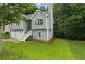 A split-level home boasts a well-manicured lawn and shaded by mature trees at 11020 Knotty Pine Pl, Hampton, GA 30228