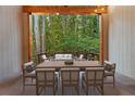Outdoor dining area with timber frame and string lights overlooking wooded backyard at 1544 Bullard Rd, Powder Springs, GA 30127