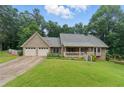 Charming home featuring a two-car garage, front porch, and lush landscaping at 2868 Wood Park Nw Trce, Kennesaw, GA 30152