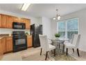 Cozy kitchen with black appliances and wood cabinets next to a dining area with natural lighting at 3516 Waldrop Trl, Decatur, GA 30034