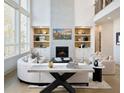 Bright and airy living room featuring a fireplace, built-in shelving, and large windows at 2480 Bleckley Pl, Cumming, GA 30041