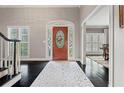 Front Foyer with decorative front door, white trim, dark hardwood floors, and a view to the dining room at 4030 River Ridge Se, Marietta, GA 30067