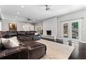 Spacious living room with white brick fireplace, dark floors, and French doors leading to the backyard at 4030 River Ridge Se, Marietta, GA 30067