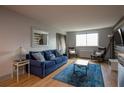 Cozy living room featuring a blue couch, wood floors, a mirror, and comfortable seating at 215 Piedmont Ne Ave # 804, Atlanta, GA 30308