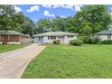Single-story home featuring a well-maintained lawn, a long driveway, and mature trees in the background at 2756 Gresham Se Rd, Atlanta, GA 30316