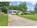 Single-story home boasts a spacious front yard with mature trees, a long driveway, and a welcoming exterior at 2756 Gresham Se Rd, Atlanta, GA 30316