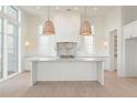 Modern kitchen features a center island, stylish lighting, and white cabinetry at 260 Guild Ln, Fayetteville, GA 30214