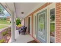 Cozy front porch with seating, brick columns, and a patterned glass front door at 2005 Ashton Pointe Dr, Dacula, GA 30019