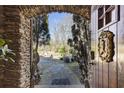 Arched stone doorway reveals a serene garden, promising a unique and enchanting home experience at 3000 Cathedral Place Pl, Decatur, GA 30034
