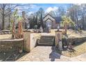 Home exterior featuring a stone wall, stairway, palm trees, and statues, creating a regal entrance at 3000 Cathedral Place Pl, Decatur, GA 30034
