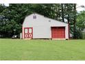 Spacious outbuilding with red doors for storage or workshop potential, set on a well-maintained lawn at 199 Candy Ln, Canton, GA 30115