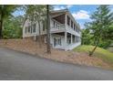 Charming home exterior showcasing a wrap-around porch, lush landscaping, and a basketball court at 2216 Trammel Rd, Cumming, GA 30041