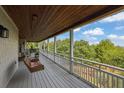 Expansive porch with a wooden ceiling, swing chair, and views of the surrounding nature at 2216 Trammel Rd, Cumming, GA 30041
