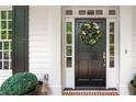 Elegant front door adorned with a wreath, sidelights, and transom window adding character to this inviting home at 8643 Ellard Dr, Alpharetta, GA 30022