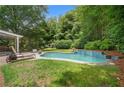 Private backyard pool surrounded by lush greenery and landscaping, providing a serene oasis for relaxation and recreation at 8643 Ellard Dr, Alpharetta, GA 30022