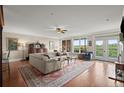 Bright living room with hardwood floors, ceiling fan, and access to balcony at 3330 Overland Dr, Roswell, GA 30075