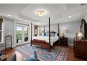 Cozy primary bedroom with a four poster bed, French doors, and a stylish tray ceiling at 3330 Overland Dr, Roswell, GA 30075