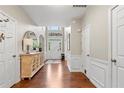 Spacious foyer with hardwood floors, white wainscoting, and decorative cabinet at 530 Camber Woods Dr, Roswell, GA 30076